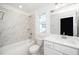 Bright bathroom with tub and shower combination, white vanity and modern fixtures at 1207 Chaney Rd, Raleigh, NC 27606