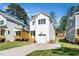 Charming white two-story home with a well-manicured lawn, front-facing garage, and wooden steps at 1207 Chaney Rd, Raleigh, NC 27606