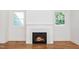 Close up of white fireplace with gas logs and hardwood floors at 1207 Chaney Rd, Raleigh, NC 27606