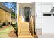 Inviting front entrance with a glass door, wooden steps, and fresh landscaping details at 1207 Chaney Rd, Raleigh, NC 27606
