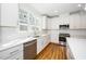 Bright eat in kitchen with white cabinets, stainless steel appliances, and a large window at 1207 Chaney Rd, Raleigh, NC 27606