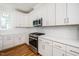 Kitchen with white cabinets, stainless steel appliances, and a large window at 1207 Chaney Rd, Raleigh, NC 27606