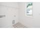 Well-lit laundry room with new tile floors and a window for natural light and ventilation at 1207 Chaney Rd, Raleigh, NC 27606