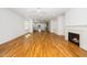 Open concept living room with hardwood floors, fireplace and open view into eat in kitchen at 1207 Chaney Rd, Raleigh, NC 27606