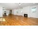Bright living room with hardwood floors, fireplace and open view of kitchen with white cabinetry at 1207 Chaney Rd, Raleigh, NC 27606