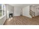 The living room is bright and open with wood floors, fireplace, and staircase at 125 Pisgah St, Sanford, NC 27330