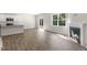 Spacious living area featuring modern fireplace, wood floors and open kitchen at 125 Pisgah St, Sanford, NC 27330