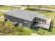Aerial shot of home featuring a deck, gray roof, and brick exterior, set on a grassy lot bordered by a chain link fence at 13832 Nc 96 N Hwy, Zebulon, NC 27597