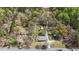 Overhead perspective reveals the house's location with access road, a lawn, carports, and a backdrop of lush trees at 13832 Nc 96 N Hwy, Zebulon, NC 27597