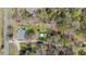 Aerial view of the property showcasing the house with a deck, driveways, carports, lawn, and surrounding trees at 13832 Nc 96 N Hwy, Zebulon, NC 27597