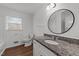 Well-lit bathroom with a granite vanity top, white cabinets, updated fixtures, and a window at 13832 Nc 96 N Hwy, Zebulon, NC 27597