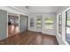 Bright living room with wood floors, gray brick wall, and expansive windows leading to an outdoor deck at 13832 Nc 96 N Hwy, Zebulon, NC 27597