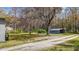 Landscape featuring a graveled driveway, green lawn, with a home and detached carport visible in the background at 13832 Nc 96 N Hwy, Zebulon, NC 27597