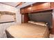 RV bedroom with plush bed, cabinets, and a window with a brown curtain at 142 Blackhawk Dr, Louisburg, NC 27549