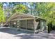 Attractive green home with a screened porch, gravel landscaping, and lush surroundings at 142 Blackhawk Dr, Louisburg, NC 27549