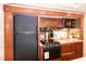Compact RV kitchen featuring modern appliances, wooden cabinets, and a black fridge at 142 Blackhawk Dr, Louisburg, NC 27549