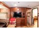 Cozy RV living area with TV, wooden storage cabinets, a single chair, and a window at 142 Blackhawk Dr, Louisburg, NC 27549