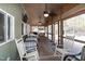Spacious screened-in porch with a daybed, rocking chairs, tv, and views of the wooded surroundings at 142 Blackhawk Dr, Louisburg, NC 27549