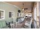 Inviting screened-in porch with rocking chairs, daybed, TV, and plenty of natural light at 142 Blackhawk Dr, Louisburg, NC 27549