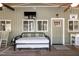 Cozy screened-in porch with daybed, rocking chair, mounted tv and view of windows and door at 142 Blackhawk Dr, Louisburg, NC 27549