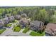 An elevated view of an elegant brick home in a cul-de-sac with lush greenery and mature trees at 1512 Piazzo Ct, Apex, NC 27502