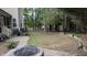 Spacious backyard featuring a fire pit, patio and lawn with wooded backdrop at 1512 Piazzo Ct, Apex, NC 27502