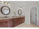 Double sink bathroom with dark cabinets, granite countertops, and decorative mirrors at 1512 Piazzo Ct, Apex, NC 27502