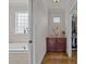 Bathroom with a soaking tub, tile walls, vanity and a walk-in closet at 1512 Piazzo Ct, Apex, NC 27502