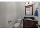 Elegant half bathroom features a dark wood vanity, black countertop, and decorative mirror at 1512 Piazzo Ct, Apex, NC 27502