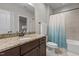 Granite vanity in bathroom with combined shower and tub with a bright blue and white curtain at 1512 Piazzo Ct, Apex, NC 27502