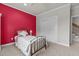 Bedroom with neutral carpet, red accent wall, and spacious closet at 1512 Piazzo Ct, Apex, NC 27502
