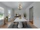 Formal dining room with a white table, elegant chandelier, wainscoting and large windows at 1512 Piazzo Ct, Apex, NC 27502
