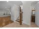 Bright entryway with hardwood floors, staircase, and view of the living room and half bathroom at 1512 Piazzo Ct, Apex, NC 27502