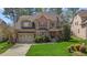Charming brick two-story home featuring a manicured lawn, attached garage, and covered front porch at 1512 Piazzo Ct, Apex, NC 27502