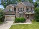 Charming two-story brick home with a well-manicured lawn, covered porch and attached garage at 1512 Piazzo Ct, Apex, NC 27502