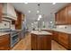 Open kitchen boasts stainless appliances, granite counters, hardwood floors, and a center island at 1512 Piazzo Ct, Apex, NC 27502