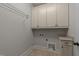 Functional laundry room with overhead cabinets, utility sink, and granite countertop space at 1512 Piazzo Ct, Apex, NC 27502