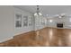 Sun-filled living room with hardwood floors, multiple windows, fireplace, and a ceiling fan at 1512 Piazzo Ct, Apex, NC 27502