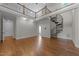 Open living room with hardwood floors, a spiral staircase, and a view to the second-floor balcony at 1512 Piazzo Ct, Apex, NC 27502