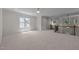 Spacious loft area featuring neutral carpet, large windows, and a staircase for flexible living at 1512 Piazzo Ct, Apex, NC 27502