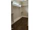 Bright walk-in closet with custom shelving, wood rods and hardwood floors create an organized space at 1512 Piazzo Ct, Apex, NC 27502