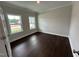 Clean, empty room featuring hardwood floors, a neutral color scheme and lots of natural light from two windows at 1572 Bright Coral Trl, Wendell, NC 27591