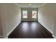 Empty room with hardwood floors, crown molding, neutral paint and ample natural light from two windows at 1572 Bright Coral Trl, Wendell, NC 27591