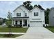 Beautiful white two-story home featuring a covered porch, well-manicured lawn, and a two-car garage at 1572 Bright Coral Trl, Wendell, NC 27591