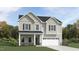 Charming two-story home featuring a front porch, two-car garage, and board and batten siding at 1572 Bright Coral Trl, Wendell, NC 27591