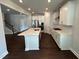 Bright open kitchen features white cabinets, a large island, stainless steel appliances, and hardwood floors at 1572 Bright Coral Trl, Wendell, NC 27591
