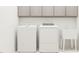 Functional laundry room featuring a washer, dryer, utility sink, and storage cabinets at 1572 Bright Coral Trl, Wendell, NC 27591