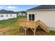 Wooden deck with railings extends from the home, offering a relaxing outdoor space with steps down to the lawn at 170 Brookhaven Dr, Spring Hope, NC 27882