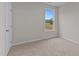 Bright bedroom featuring neutral carpet, light gray walls, and a large window showcasing scenic outdoor views at 170 Brookhaven Dr, Spring Hope, NC 27882