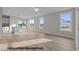 Open-concept living area with large windows, light wood floors, a kitchen island, and access to the outdoor deck at 170 Brookhaven Dr, Spring Hope, NC 27882